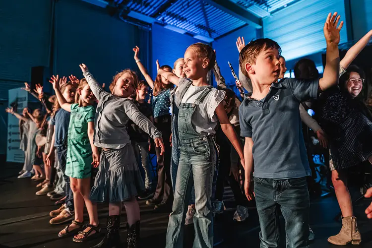 Sporthal vol kinderen in de ban van het orkest